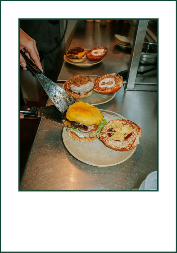 Burger being assembled in Cook kitchen